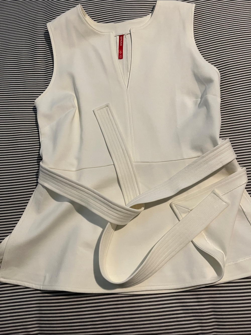 White Spanx sleeveless shirt with belt at waist. Super cute.